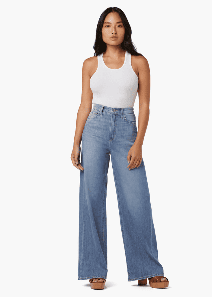 woman wearing wide leg jeans and a tank top, one of the spring 2024 fashion trends