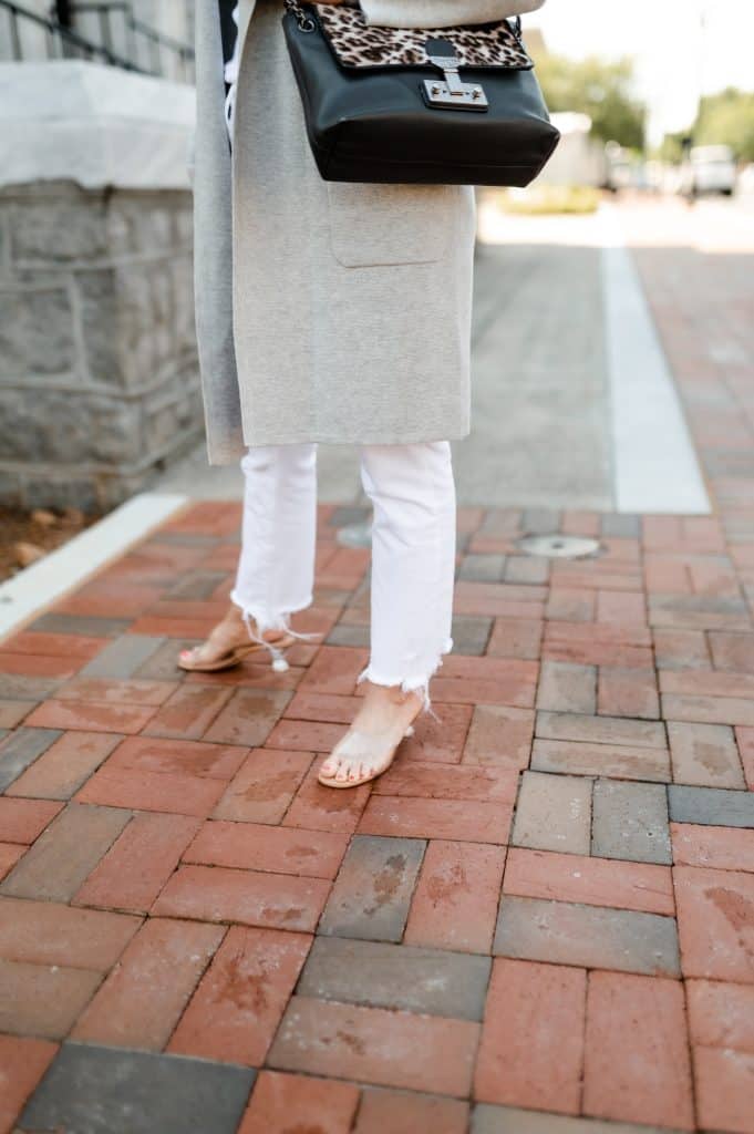 Woman wearing a pair of kitten heel slide sandals.  One of the spring 2024 fashion trends.