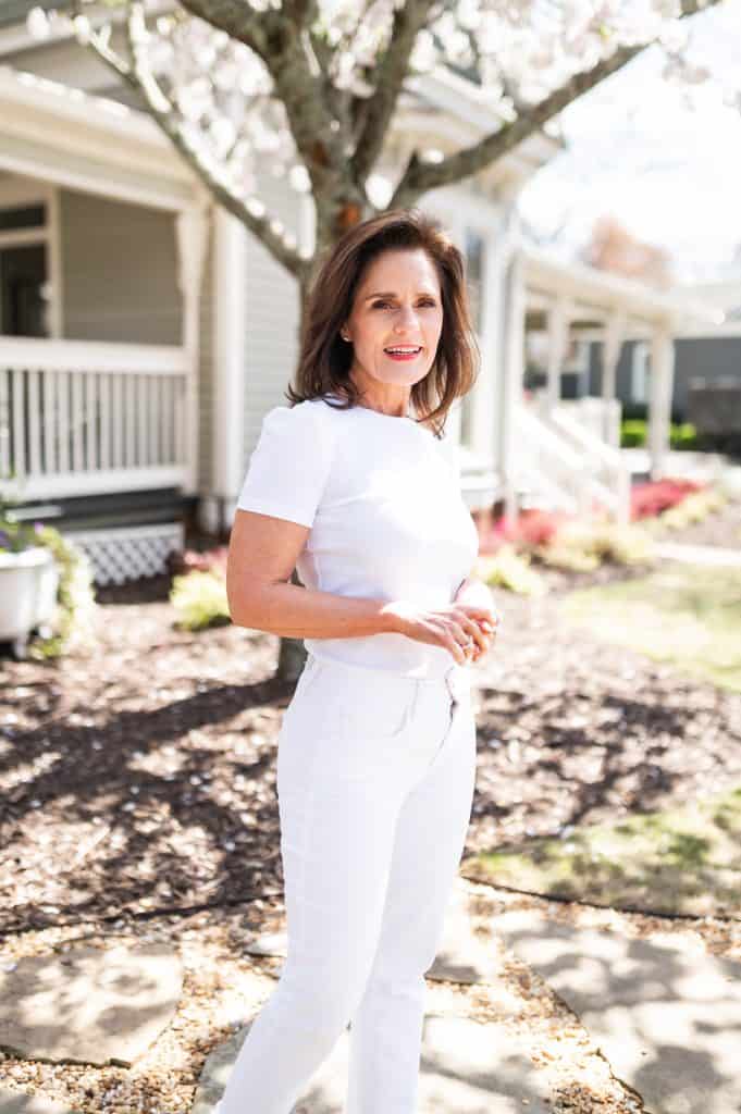 brunette woman wearing a white layering tee with white jeans, spring wardrobe essentials