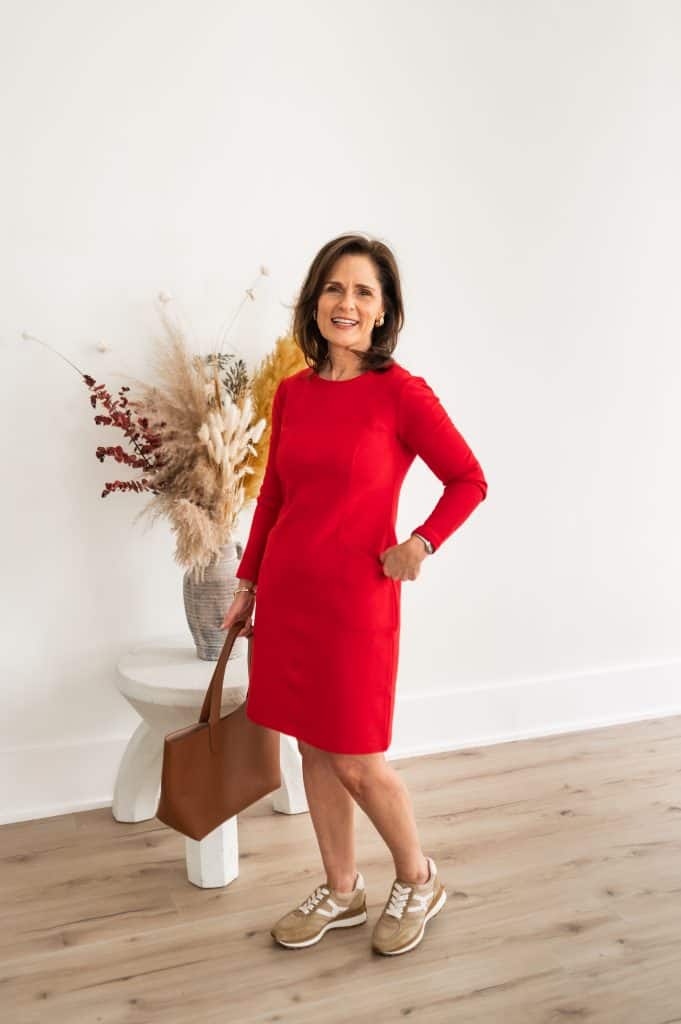 petite brunette woman wearing a red dress that hits above the knee with retro sneakers