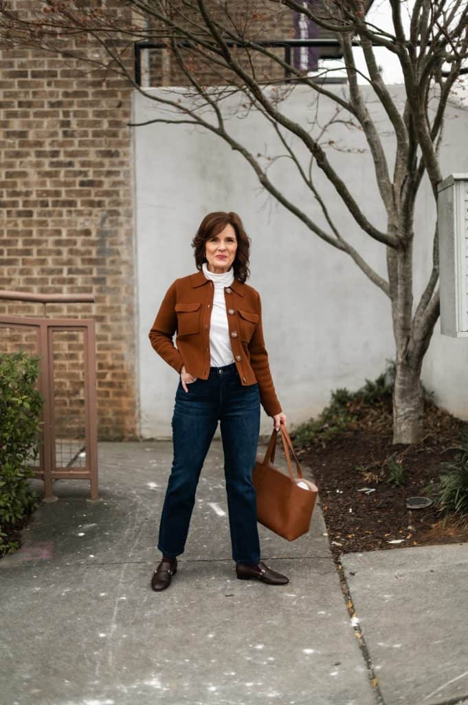 Polished winter outfit with cropped jeans, loafers, and a brown cardigan on a petite woman.