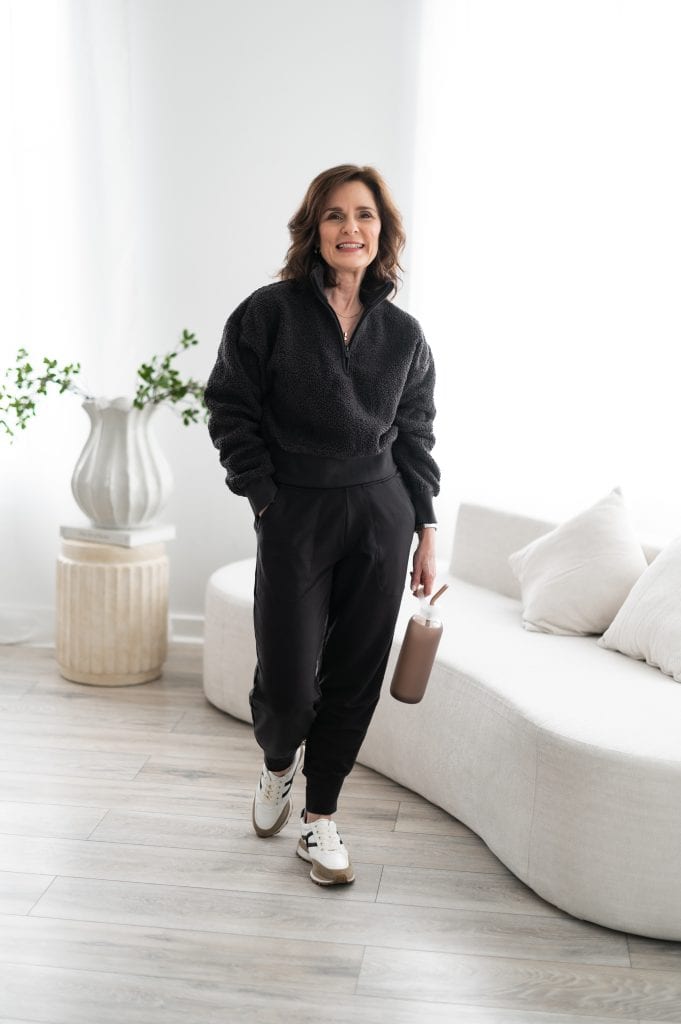 Elevated joggers paired with a cozy quarter zip for a comfortable yet polished at-home outfit on a petite frame.